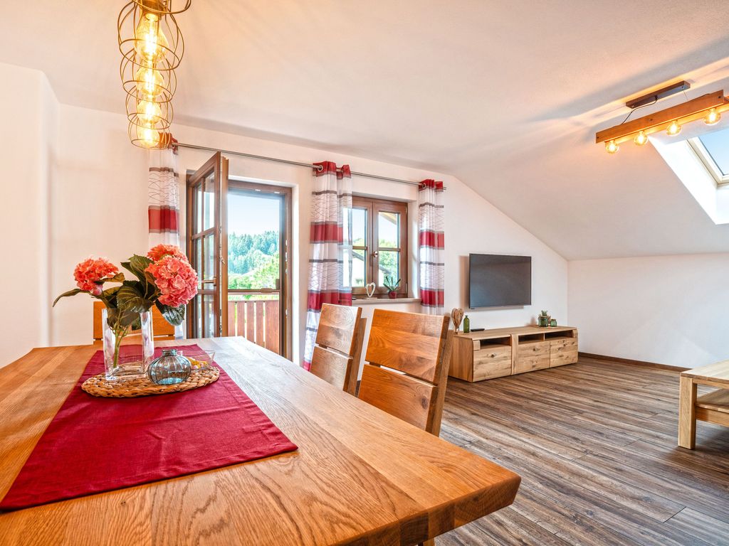 Wohnzimmer mit Flat TV und Esstisch