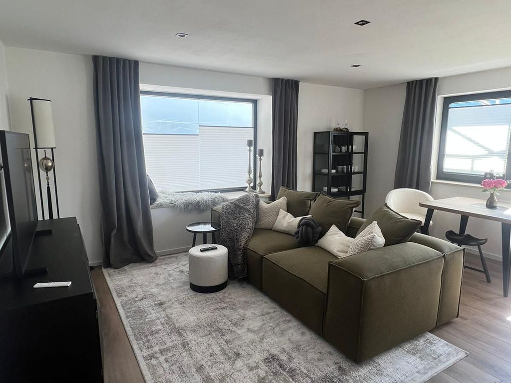 Wohnzimmer mit Couch mit Flach-TV und Essplatz