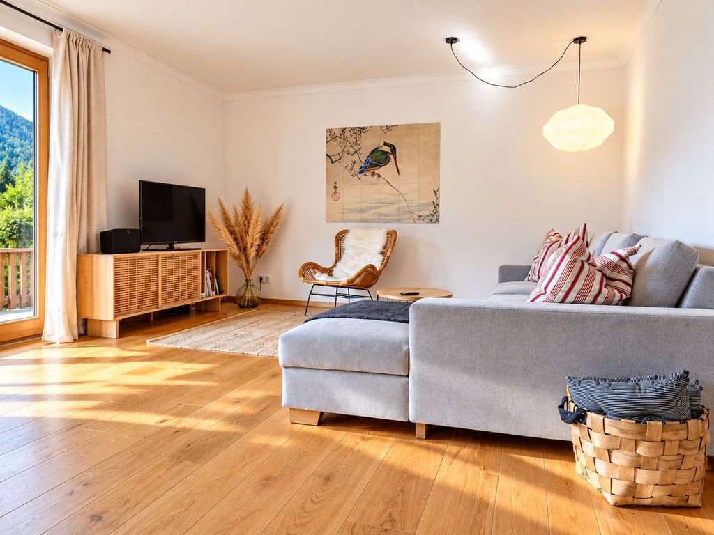 Gemütlich Wohnzimmer mit Holzbodem und Gartenblick.