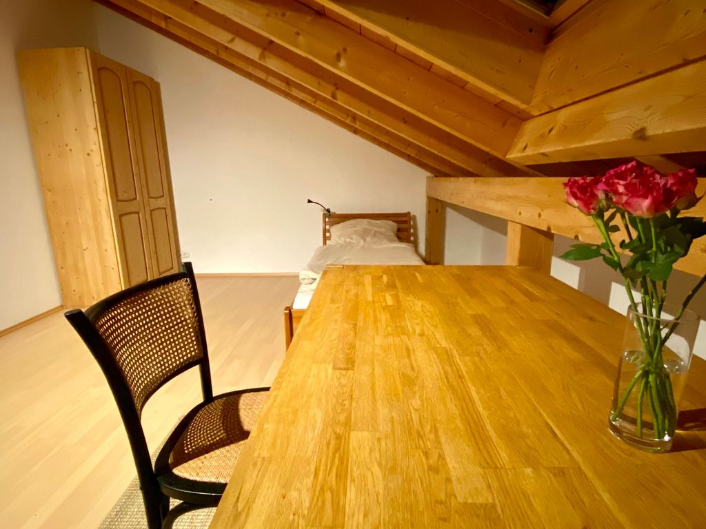 Schreibtisch mit Einzelbett im Hintergrund