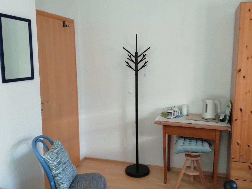 Blaues Zimmer mit Spiegel und Kleiderständer