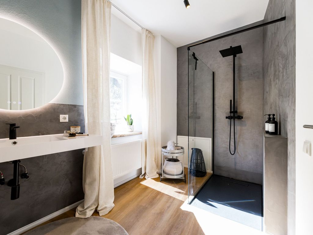 Geräumiges Badezimmer mit Waschbecken und Dusche
