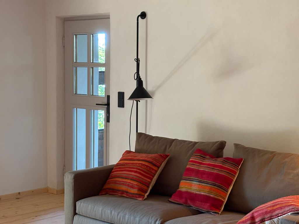 Stube mit Ausziehsofa und Tür zur Loggia