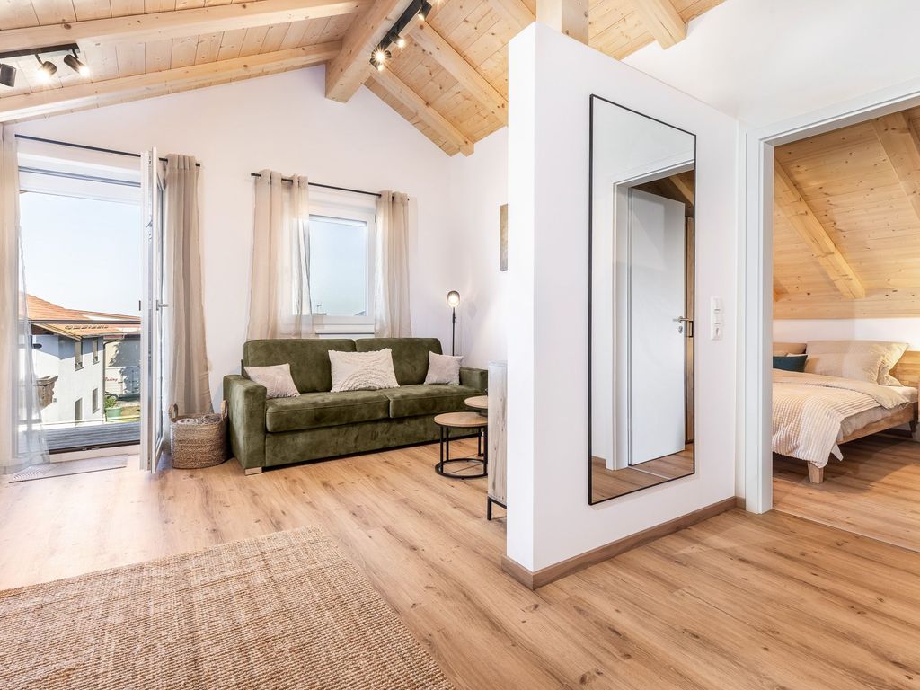 Wohnzimmer mit Schlafcouch und Schlafzimmer