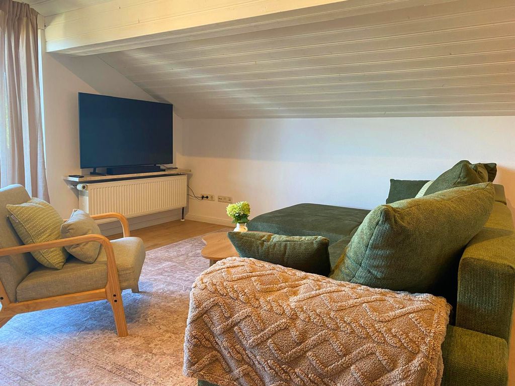 Wohnraum mit Couch und Flat-TV