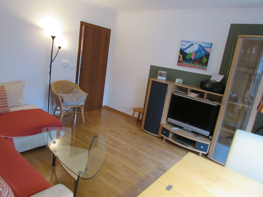 Gemütliches Wohnzimmer mit großem Ecksofa und Flachbildfernsehen