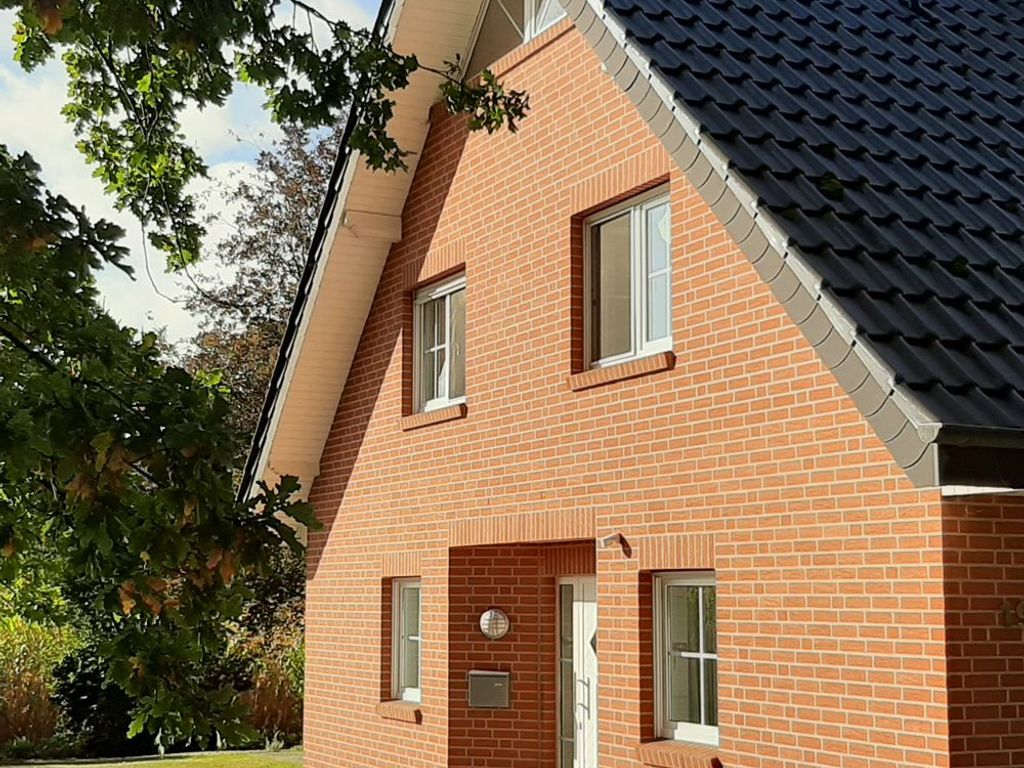 Außenansicht der Ferienwohnung Olli mit großflächigem Parkplatz direkt vor der Haustür
