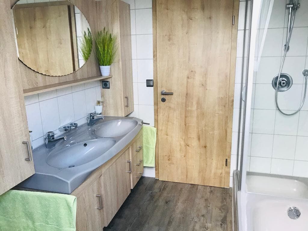 Helles Bad mit Dusche, Badewanne und WC.jpeg