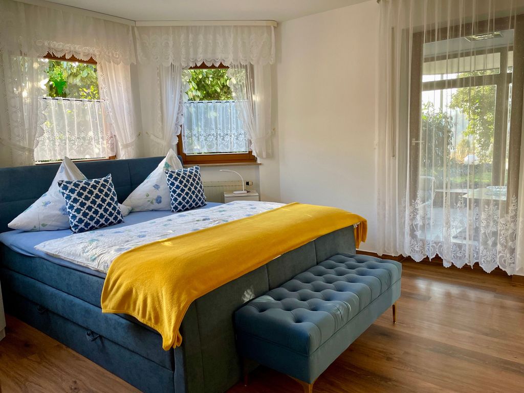 bequemes Boxspringbett mit gepolsterten Sitzbänkchen zum Anziehen.