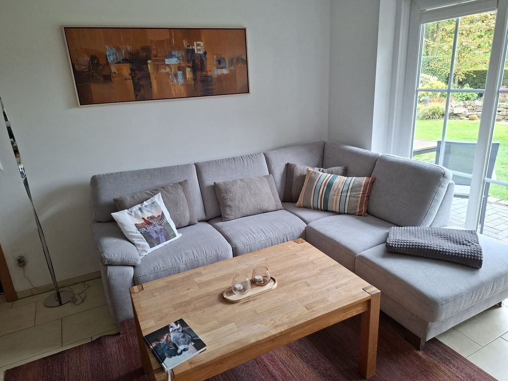 Wohnzimmer mit großem Sofa in der Ferienwohnung Am Eselhaus in Rhede