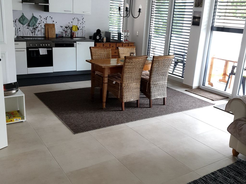 Große, geräumige Wohnküche mit Schlafsofa und mit Blick auf großzügigen Balkon