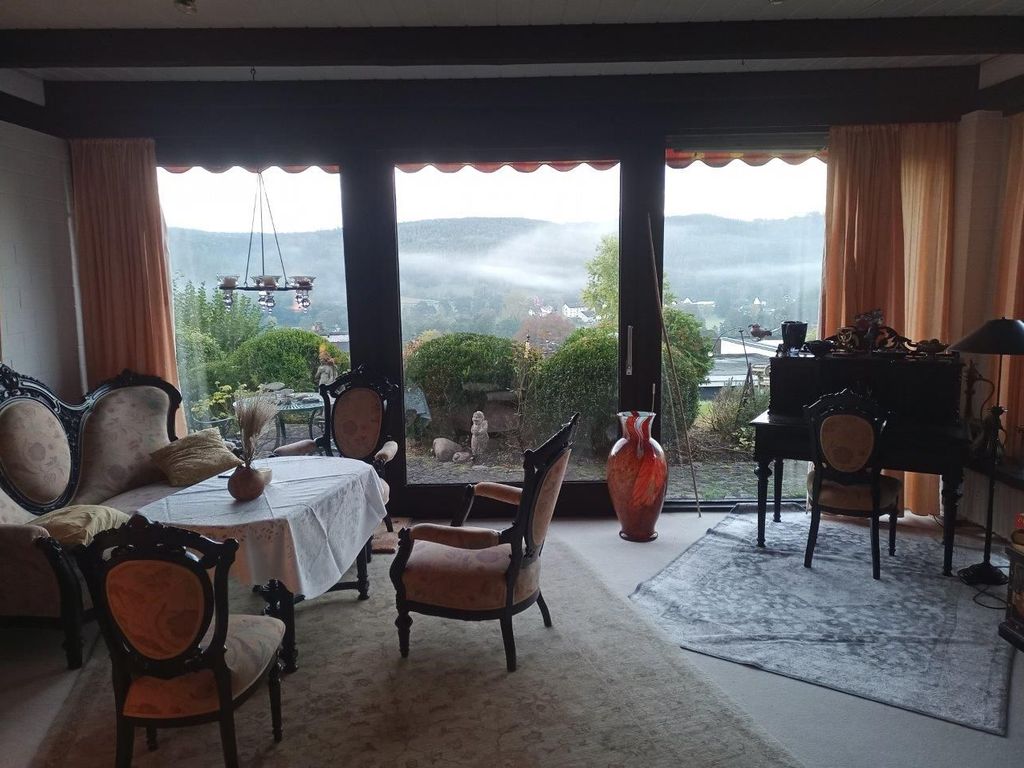 Wohnzimmer mit Sitzgruppe und Schreibtisch, Blick in das Tal und auf die Berge