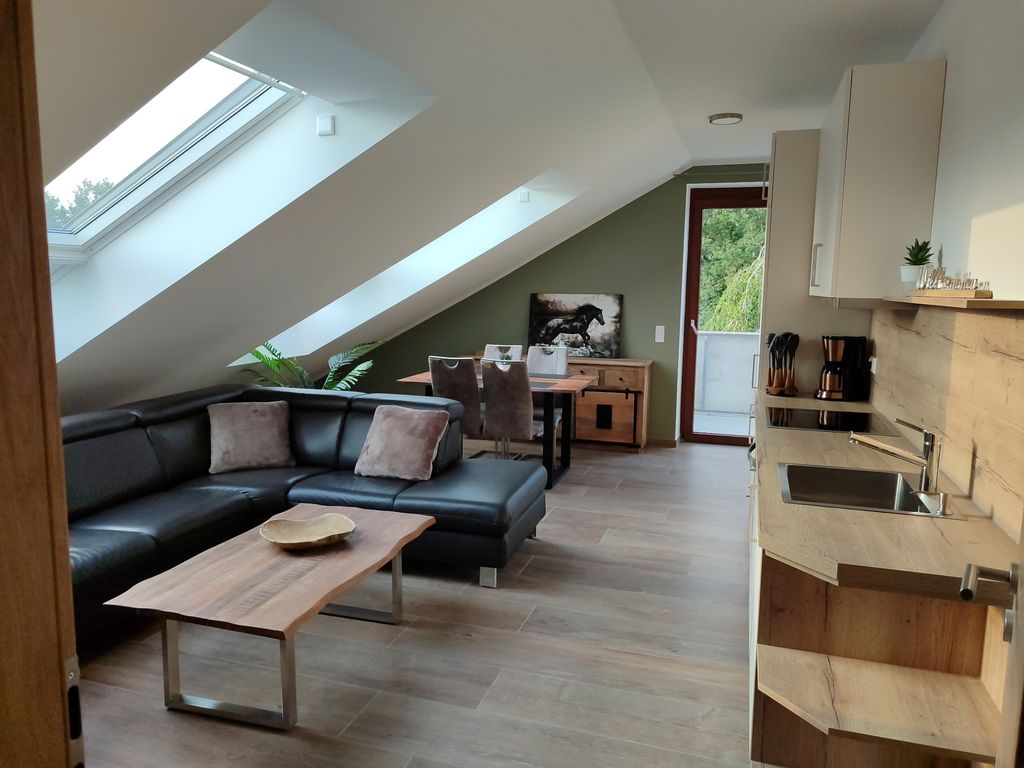 Wohnbereich mit Esstisch, Sofa und Küchenzeile