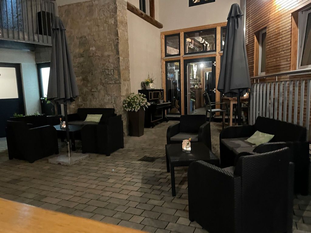 Innenhof mit Sitzgelegenheiten und Eingang ins Restaurant