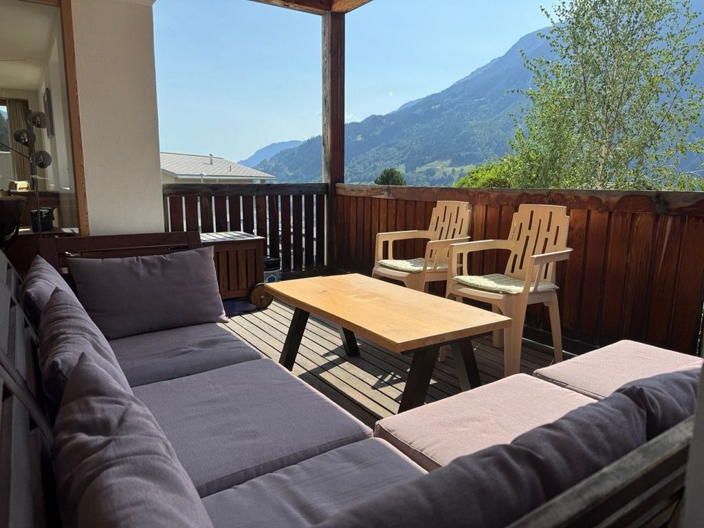 Überdachte, nach Süden ausgerichtete 11,5 m² grosse Terrasse mit Gartensofa, Tisch und Stühlen.