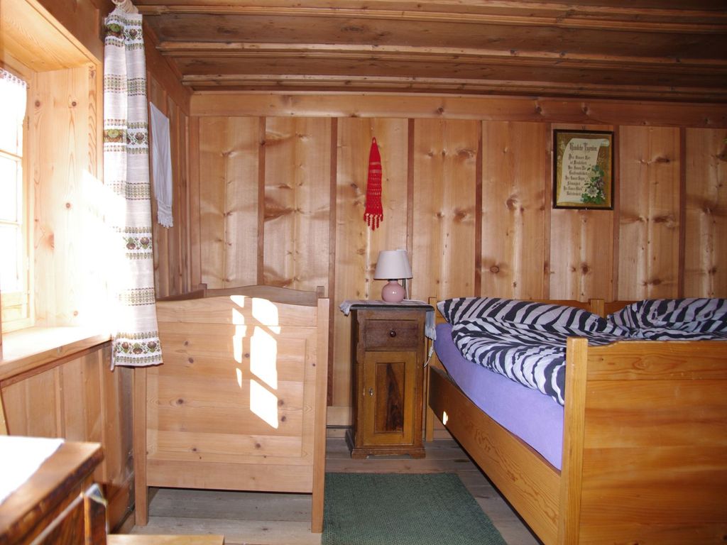 Ferienhaus Altes Walserhaus - Schlafzimmer mit Doppelbett und Kinderbett