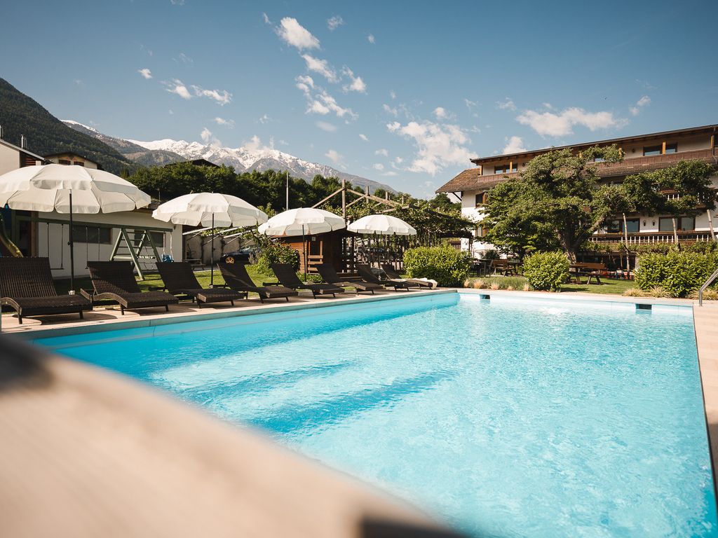 Hotelansicht mit Schwimmbad und Garten