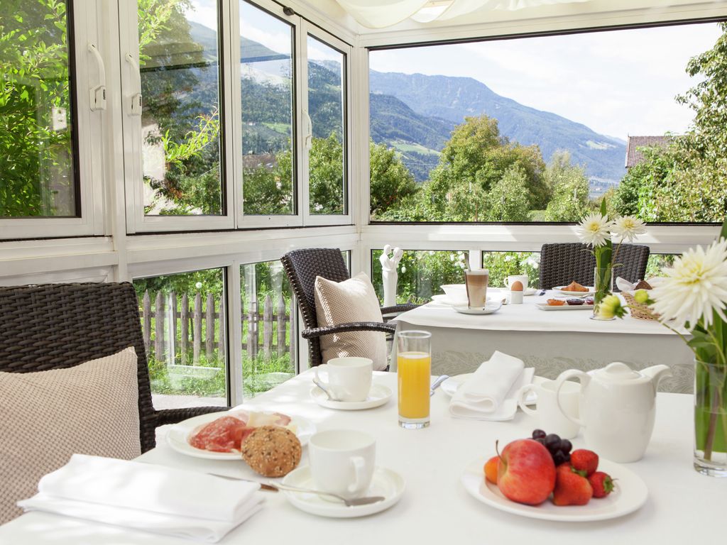 Frühstückstisch im Wintergarten mit frischen Obst, Eier vom Bauernhof und Südtiroler Qualitätsprodukten und schönen Ausblick in die Vinschgauer Bergwelt.