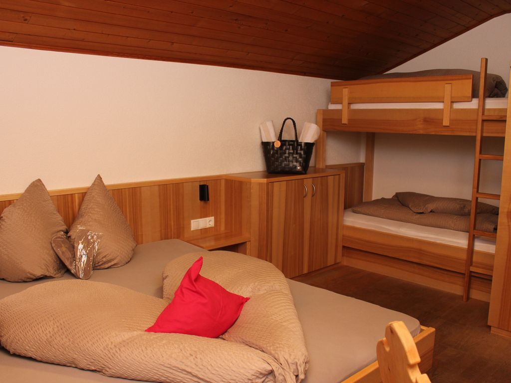 Helles Mehrbettzimmer mit Doppelbett und Stockbett – perfekt für einen entspannten Urlaub in Südtirol.