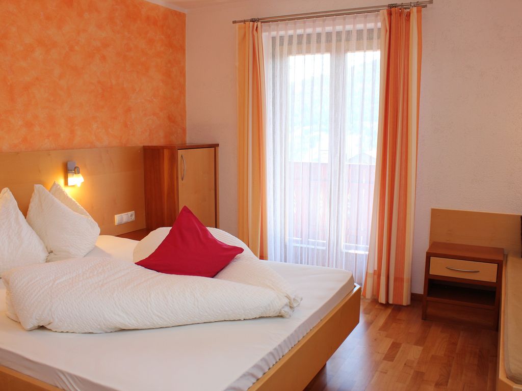 Helles Doppelzimmer mit traditionellem Alpenflair und modernem Komfort für erholsame Nächte.