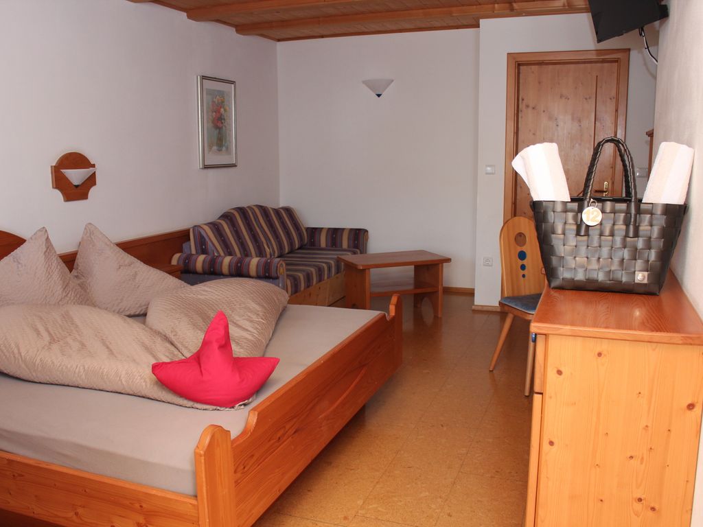 Großzügiges Zimmer mit komfortablem Doppelbett und ausziehbarer Schlafcouch – ideal für Paare oder Familien.