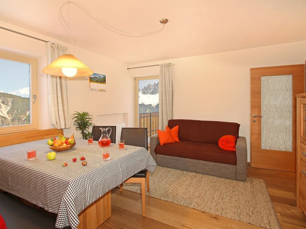 Geräumiger Wohnraum mit ausziehbarem Schlafsofa und traumhaftem Blick zur Geislergruppe.
