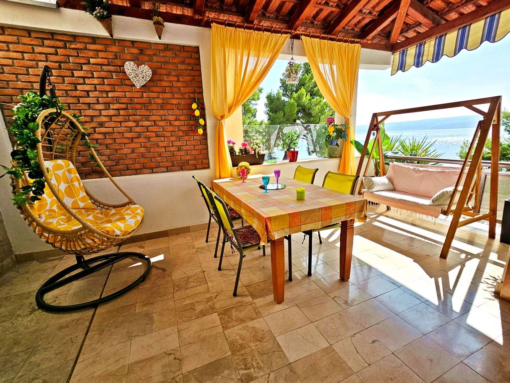 mit überdachter Terrasse und Balkon am Strand mit Meerblick