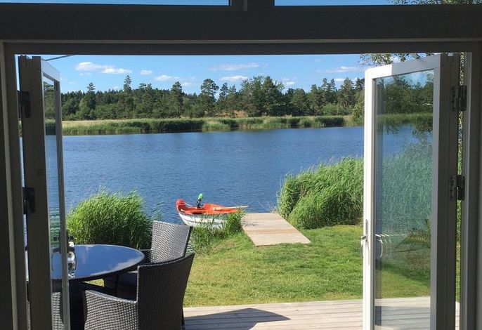 Holzhaus mit Terrasse, direkt an einer Bucht