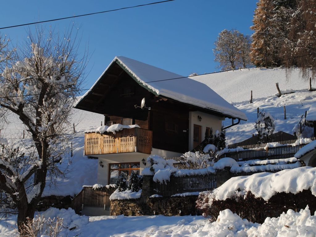 Das Ferienhaus von außen, im Winter mit schneebedecktem Dach und Balkon.