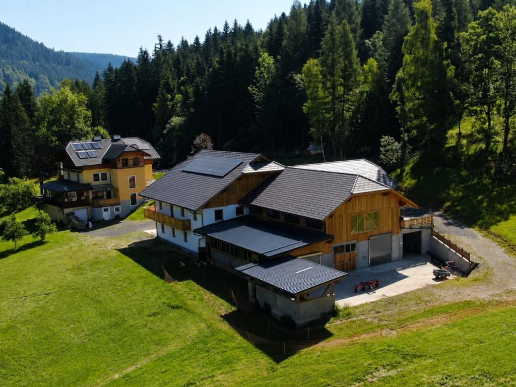 Ein idyllisch gelegener Bauernhof inmitten von saftig grünen Wiesen und dichten Wäldern.
