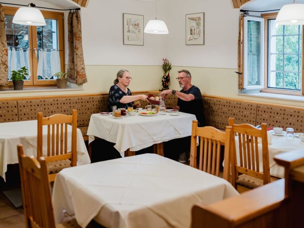 Ein gemütlicher Frühstücksraum auf dem Bauernhof mit traditionellen Holzmöbeln und hellem, freundlichem Ambiente.