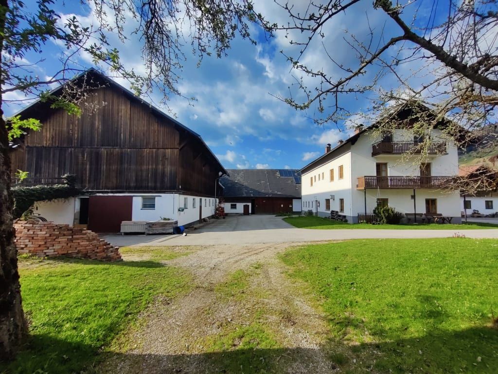Außenansicht des Bauernhofs mit Stall und Wohngebäude.