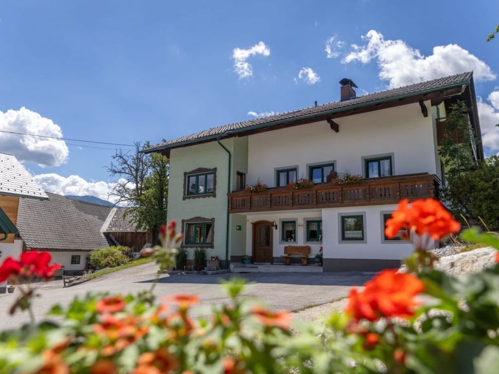 Unser Ferienhof Mittermair mit traditionellem Holzbalkon und blühendem Blumenschmuck