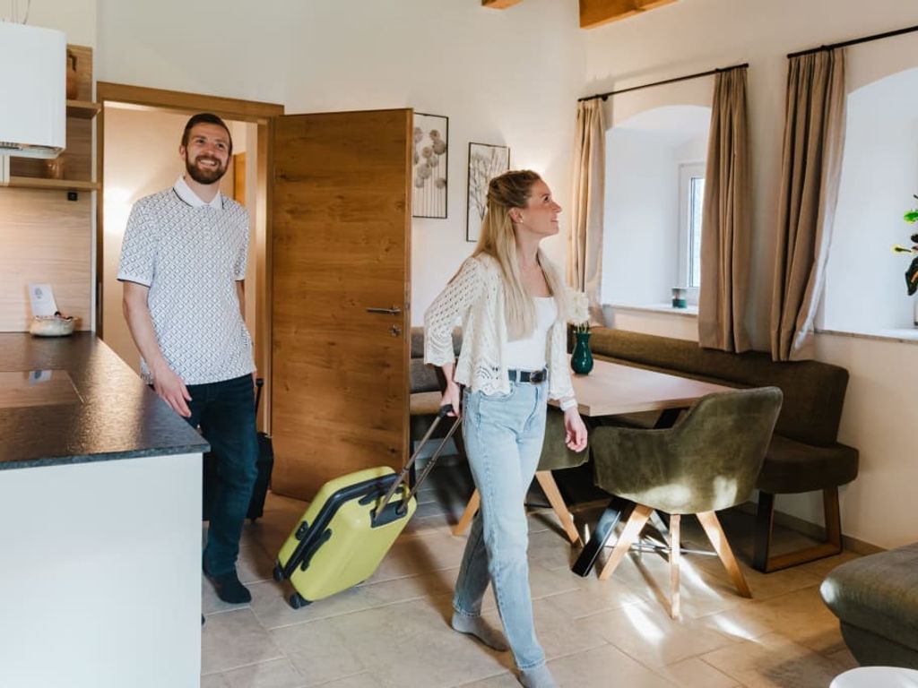 Gäste betreten die Ferienwohnung mit offener Küche und Essbereich.
