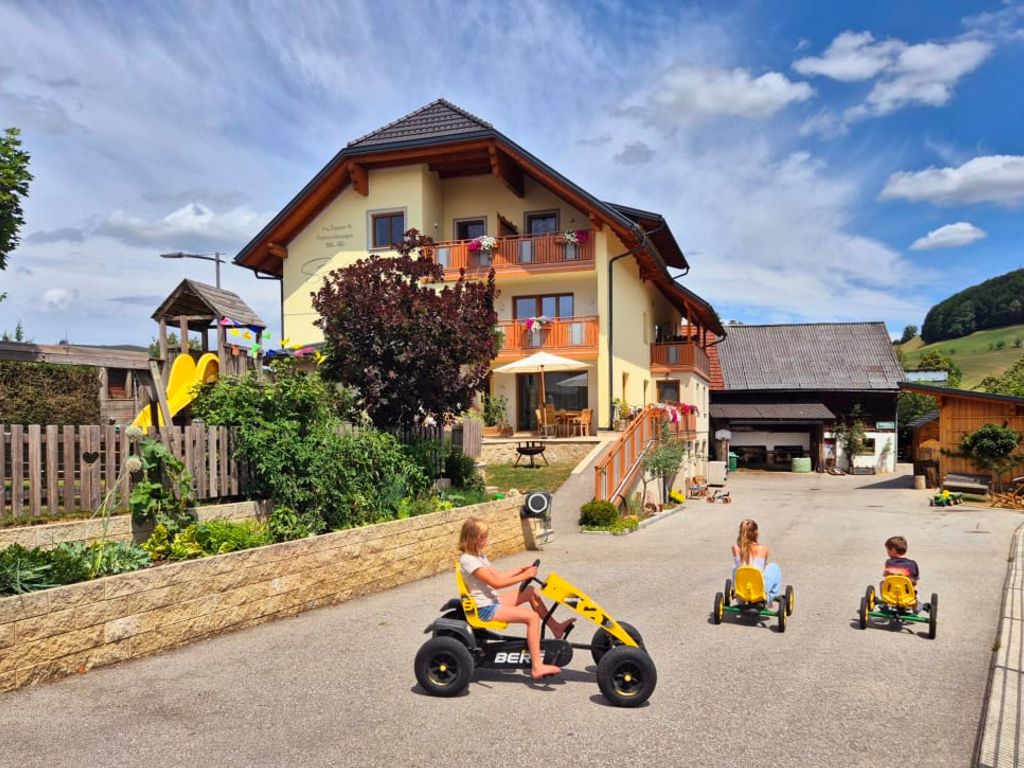 Der einladende Bauernhof mit einem großzügigen Spielbereich im Hof und einem Kinderspielplatz.