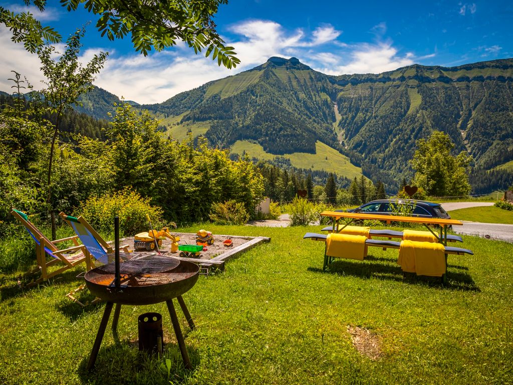 Der Garten des Bauernhofs bietet einen Grill, einen Sandkasten mit Spielzeug, Liegestühle und einen Picknicktisch mit Bergblick.