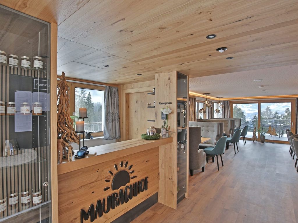 Die Rezeption des Bauernhofs mit integrierter Vitrine für Produkte und dem Speisesaal mit großen Fenstern und Ausblick ins Salzachtal.