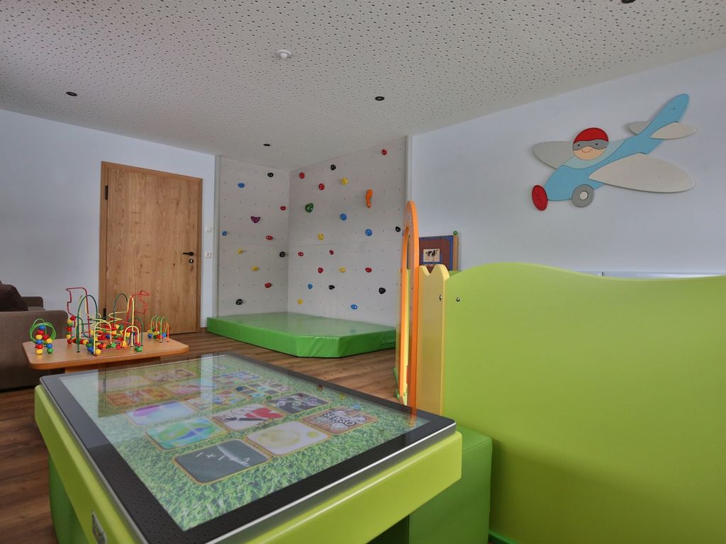 Kinderspielzimmer auf dem Bauernhof mit Boulderwand, interaktivem Spieltisch und Motorikschleifen.