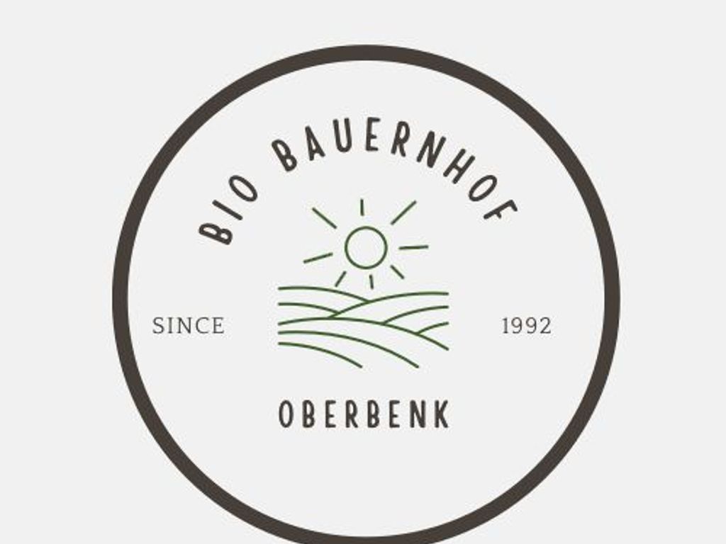 Das Logo des Bio Bauernhofs Oberbenk zeigt dessen Namen, das Gründungsjahr 1992 sowie eine Darstellung von Hügeln und Sonne.