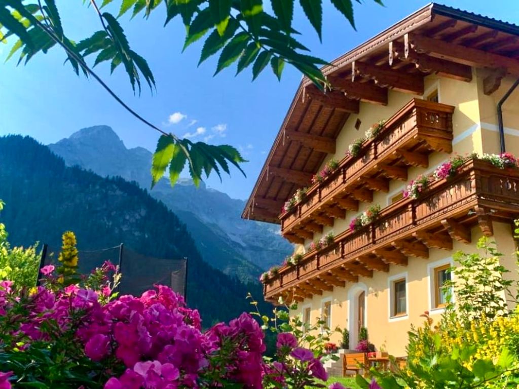 Außenansicht des Bauernhauses mit Sitzgelegenheiten vor und neben dem Haus.