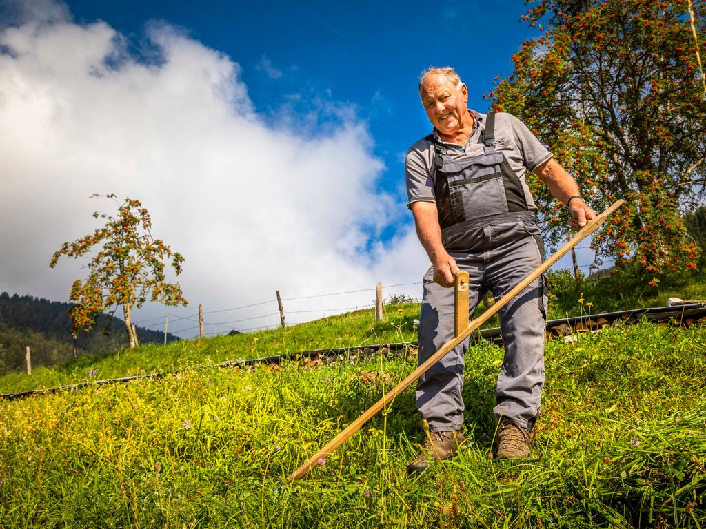 Ein Landwirt auf dem Bauernhof mit einem traditionellen Werkzeug.
