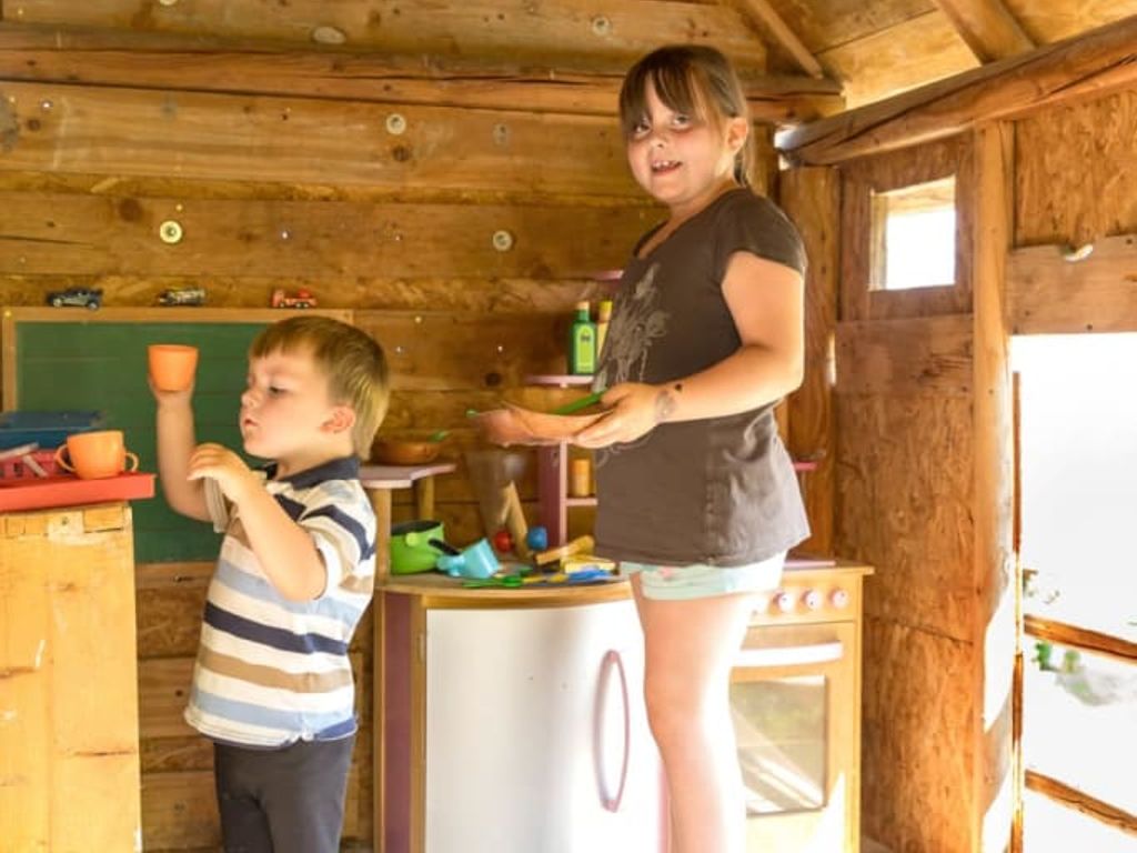 Ein gemütliches Holzspielhaus auf dem Bauernhof mit einer gut ausgestatteten Spielküche für die kleinen Gäste.