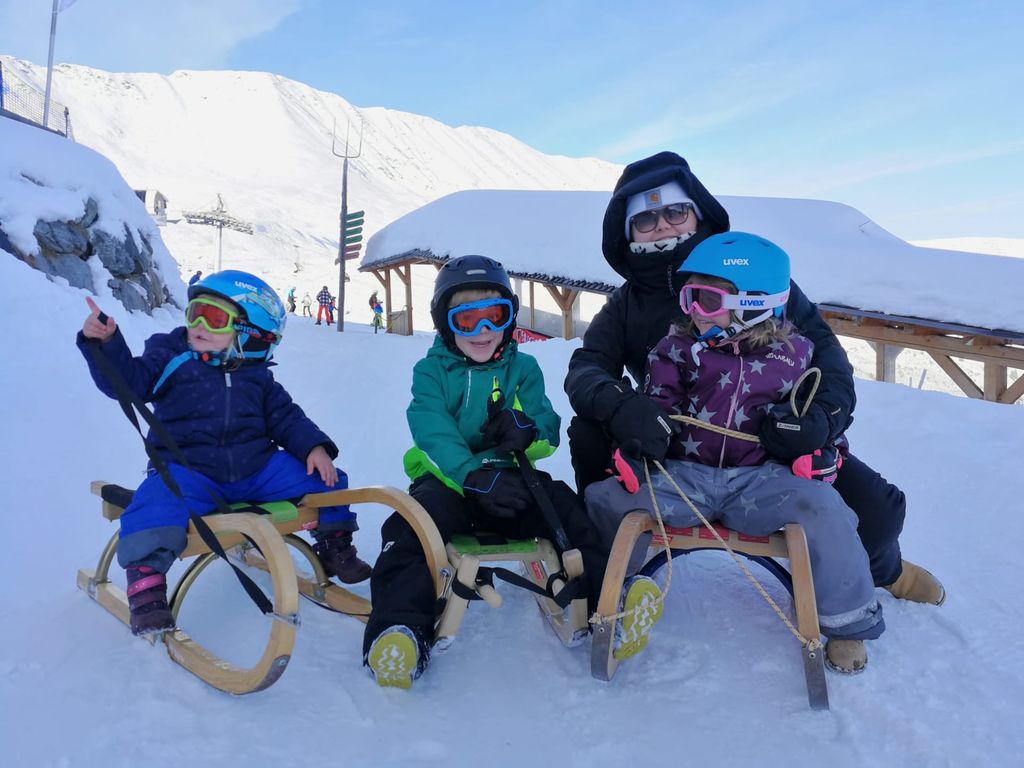 Rodelspaß für die ganze Familie in der verschneiten Berglandschaft rund um den Bauernhof.