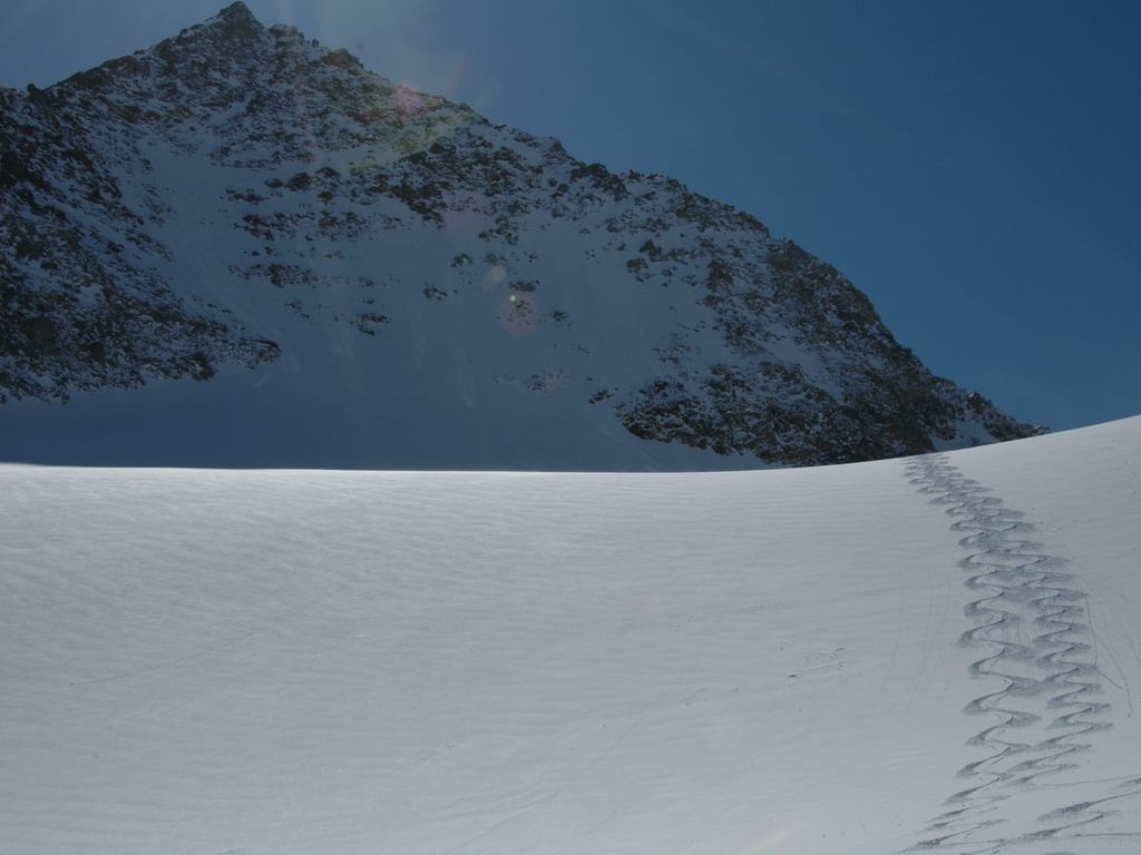 Winterliche Berglandschaft mit Skispuren in der Nähe des Bauernhofs.
