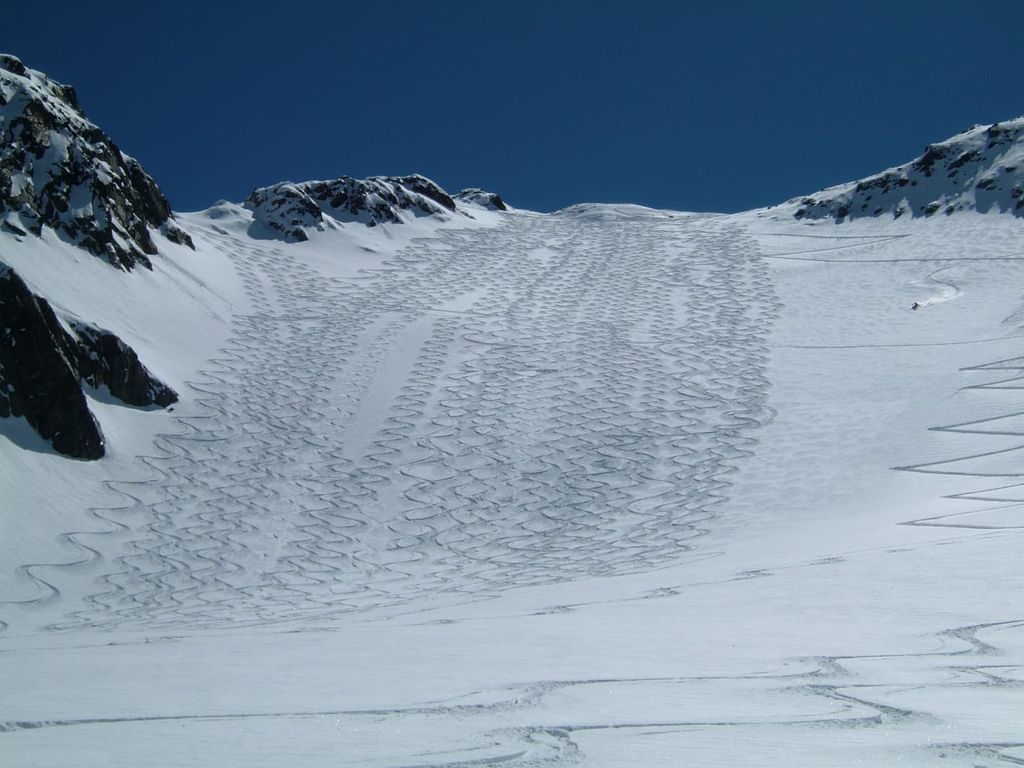 Skigebiet mit zahlreichen Skispuren auf der Piste in der Umgebung des Bauernhofs.