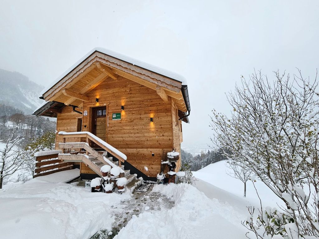 Das Ferienhaus am Hof, umgeben von Schnee, mit Außentreppe zum Eingang.