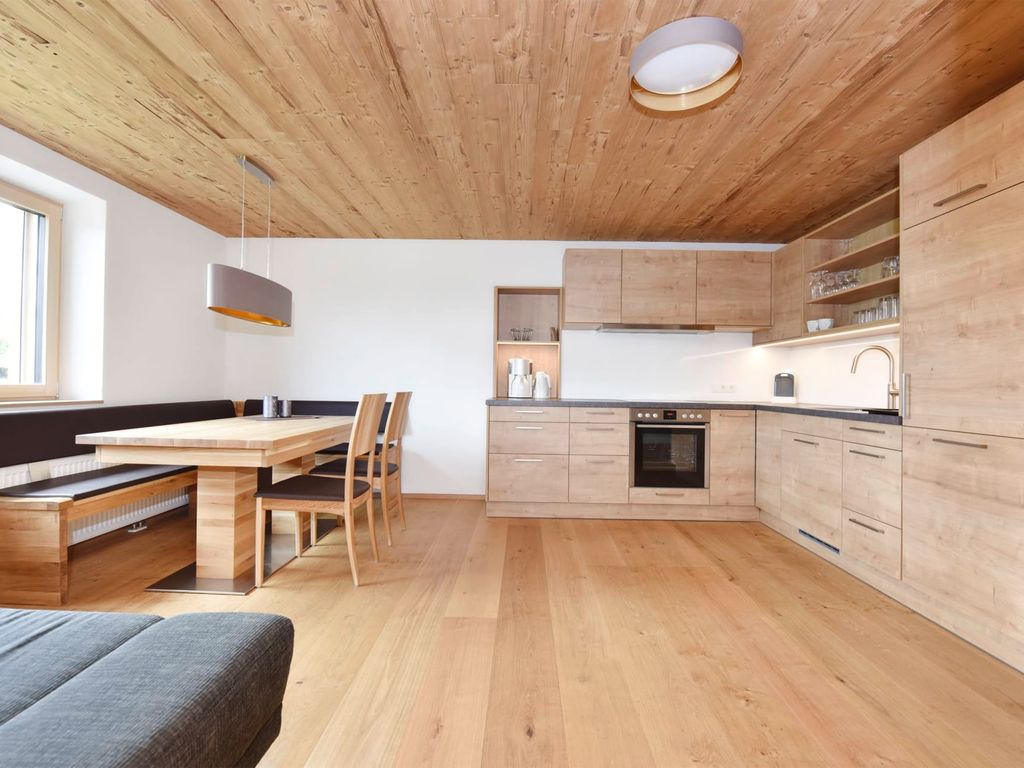 Die moderne Küche des Bauernhofs ist mit Backofen und Spüle ausgestattet und verfügt über eine Essecke mit großem Holztisch und Eckbank.