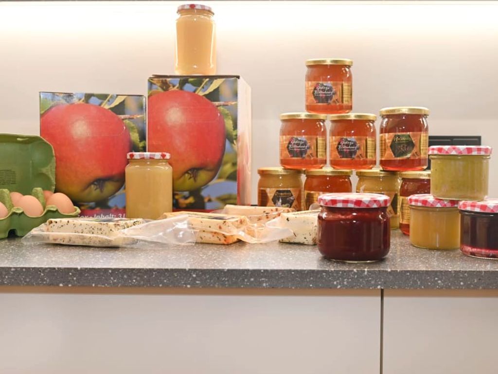 Direkt am Bauernhof erhältliche Produkte, darunter Hochgebirgshonig, Eier, Käse und hausgemachte Aufstriche.