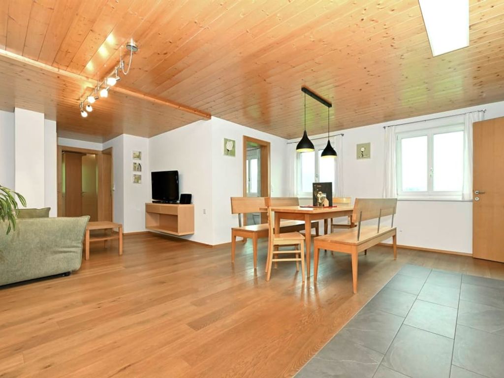 Der offene Wohnbereich der Ferienwohnung mit Sofa, TV, Esstisch und der vollausgestatteten Wohnküche.