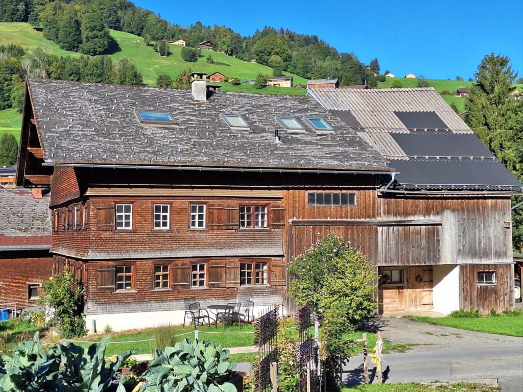Unser Haus mit charmanter Holzfassade umgeben von Wiesen und Wäldern